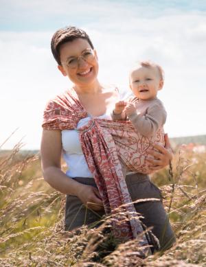 Von Mutter seitlich im Tuch getragenes Baby